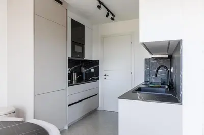 a kitchen with white cabinets and a sink at Casa del Sol Bar in Bar, Susanj