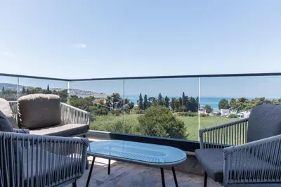 a balcony with chairs and a table and a view of the ocean at Casa del Sol Bar in Bar, Susanj