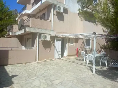 a building with a patio with a table and chairs at Inna Apartment near the Sea in Petrovac na Moru