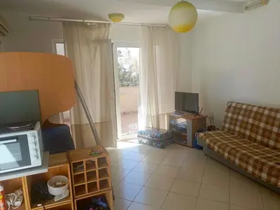a living room with a couch and a tv at Inna Apartment near the Sea in Petrovac na Moru