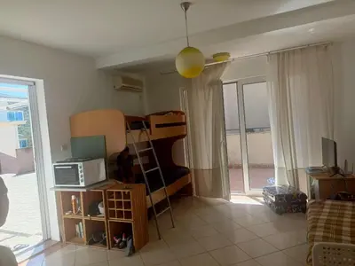 a living room with a bed and a microwave at Inna Apartment near the Sea in Petrovac na Moru