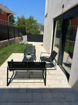 a patio with two black chairs and a table at Villa Richard in Sutomore