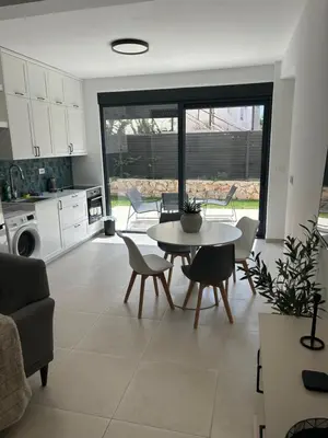 a kitchen and living room with a table and chairs at Villa Richard in Sutomore