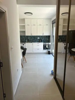 a kitchen with white cabinets and a tile floor at Villa Richard in Sutomore