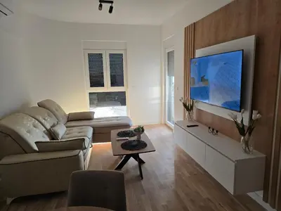 a living room with a couch and a flat screen tv at Lux Apartment Dani in Bar