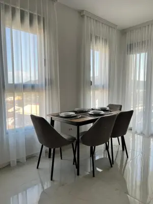 a dining room with a table and chairs and windows at Apartment L&L in Bar