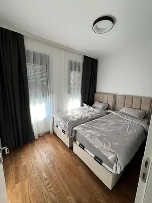 a bedroom with two beds and a window at Apartment L&L in Bar