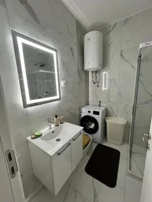 a white bathroom with a sink and a mirror at Apartment L&L in Bar