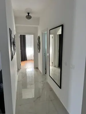 a hallway with white walls and a mirror on a wall at Apartment L&L in Bar