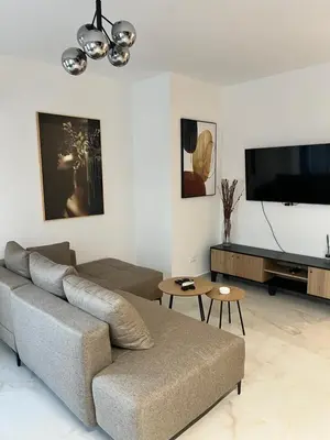 a living room with a couch and a flat screen tv at Apartment L&L in Bar