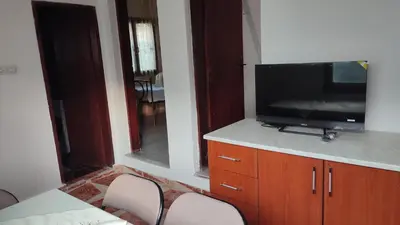 a living room with a tv and some chairs at Sweet home in Sutomore