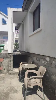 a patio with two chairs and a table and a window at Sweet home in Sutomore