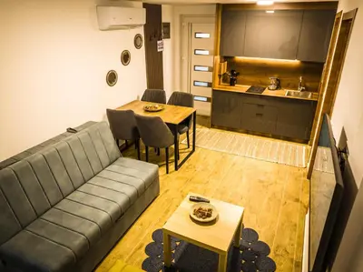 a living room with a couch and a table and a kitchen at TaNa's Apartments in Donji Štoj
