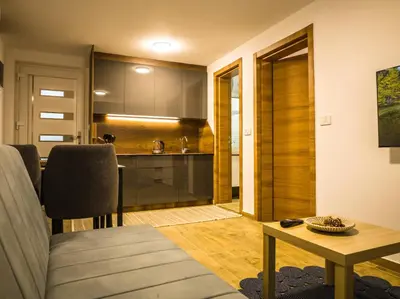 a living room with a table and a kitchen at TaNa's Apartments in Donji Štoj