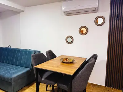 a dining room with a table and a couch at TaNa's Apartments in Donji Štoj