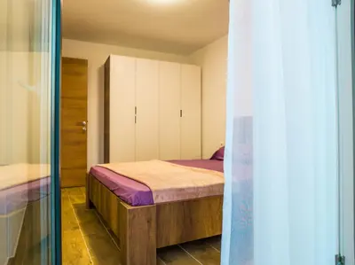 a small bedroom with a bed and a closet at TaNa's Apartments in Donji Štoj