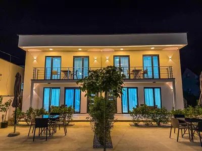 a building with tables and chairs in front of it at TaNa's Apartments in Donji Štoj