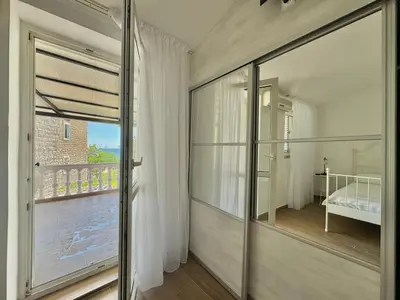 a room with a large glass window and a bedroom at Beachfront Holiday Home Rafailovici in Becici