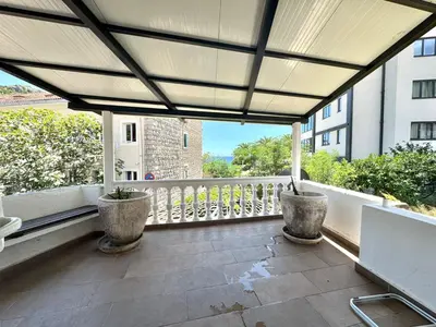 an outdoor balcony with two potted plants on it at Beachfront Holiday Home Rafailovici in Becici