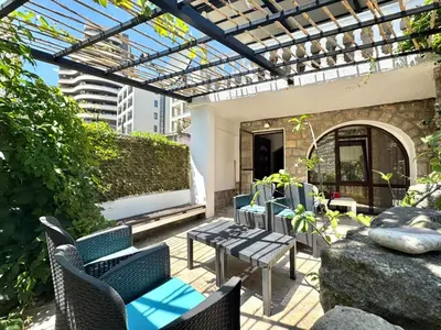 a patio with chairs and a table and a glass roof at Beachfront Holiday Home Rafailovici in Becici