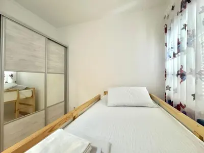 a bedroom with a bed and a large window at Beachfront Holiday Home Rafailovici in Becici