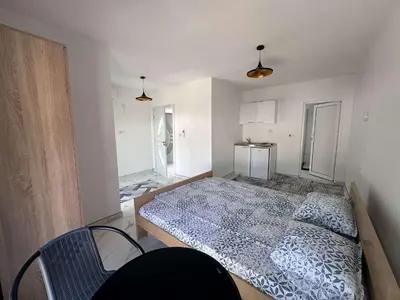 a bedroom with a bed and a refrigerator at GIS Villa in Donji Štoj