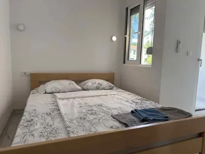 an unmade bed in a room with a window at GIS Villa in Donji Štoj