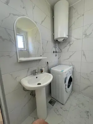 a white bathroom with a sink and a washing machine at GIS Villa in Donji Štoj