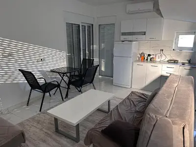 a living room with a couch and a table and a kitchen at GIS Villa in Donji Štoj