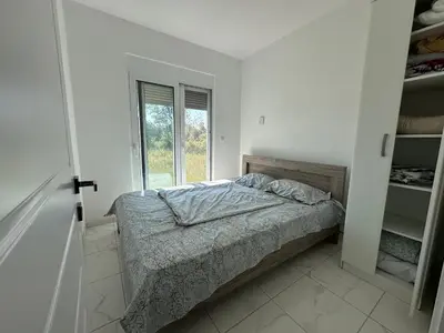 a white bedroom with a bed and a window at GIS Villa in Donji Štoj