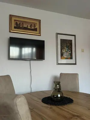 a dining room table with a vase on top of it at Apartman M5 in Cetinje