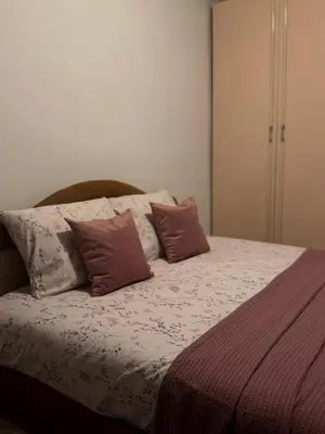 a bed with three pillows on top of it at Apartman M5 in Cetinje
