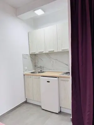 a small kitchen with white cabinets and a white refrigerator at Ulcinj Go in Ulcinj