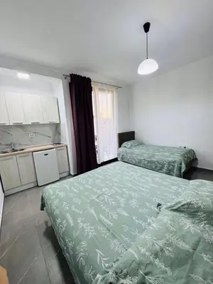 a room with two beds and a kitchen with at Ulcinj Go in Ulcinj