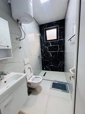 a white bathroom with a toilet and a sink at Ulcinj Go in Ulcinj