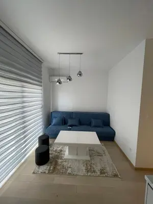 a living room with a blue couch and a table at Nata 25 in Becici