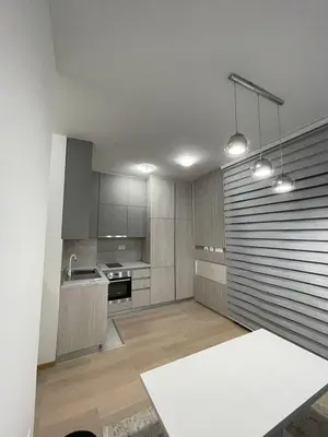 a kitchen with white cabinets and a white table at Nata 25 in Becici