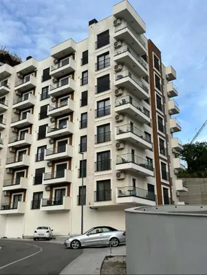 a large apartment building with cars parked in front of it at Nata 25 in Becici