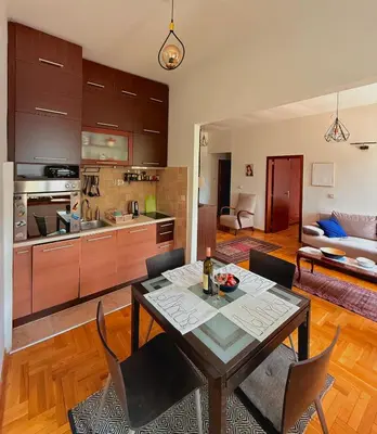 a kitchen and living room with a table and chairs at Bokeska apartment in Podgorica