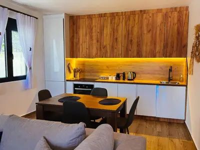 a living room with a table and a kitchen at TaNa's Villa in Donji Štoj