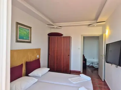 a bedroom with a bed with a television and a door at Apartments Yll in Ulcinj