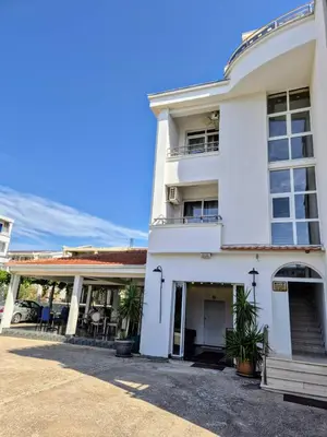 a white building with plants in front of it at Apartments Yll in Ulcinj