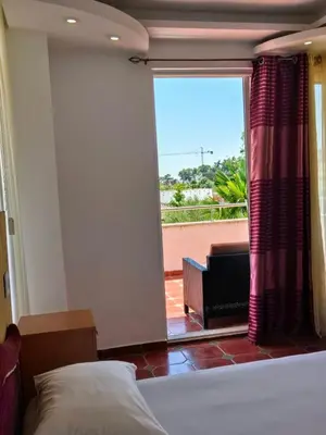a bedroom with a bed and a large window with a view at Apartments Yll in Ulcinj