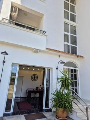 a white building with a window and a clock at Apartments Yll in Ulcinj