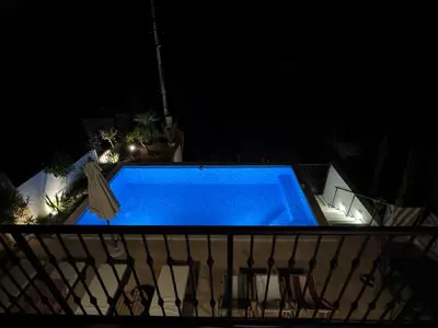 a blue swimming pool on a balcony at night at Casa del Sol Zagora in Zagora