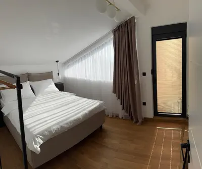 a white bedroom with a bed and a window at Casa del Sol Zagora in Zagora