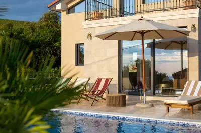 a patio with chairs and an umbrella next to a pool at Casa del Sol Zagora in Zagora