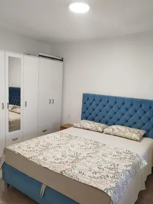 a bedroom with a blue headboard and a bed at Guest house Danica in Bar