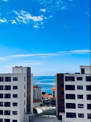 a view of two tall buildings and the ocean at Apartman Gioia in Becici