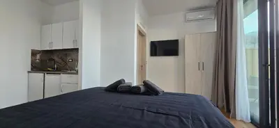 a bedroom with a bed with a blue blanket at Beachfront Blue Panorama in Bar